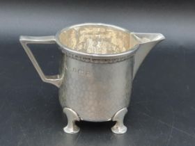 A George VI heavy silver Milk Jug with leafage frieze and hammered design on four shaped feet,