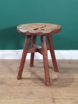 An Arts and Crafts style Stool with pierced, dished seat, carved frieze on chamfered square supports