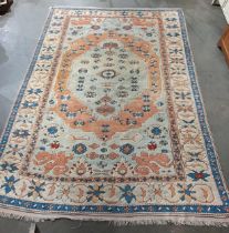 A Turkish Carpet with floral designs to the multiple borders and central stepped medallion on a blue