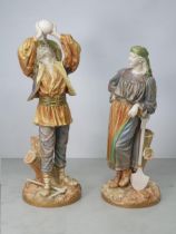 A large pair of Royal Worcester shotsilk figures, a lady resting on a shovel and man drinking from a