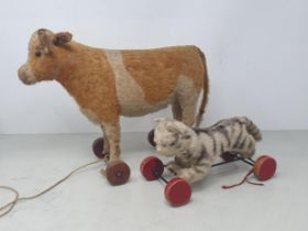 A vintage Steiff pull along Cow with button in ear (some wear to horns and tail) 10in H, and a