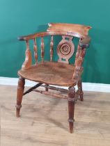 A 19th Century oak and elm Captain's Chair having rounded splat back, shaped seat on turned supports