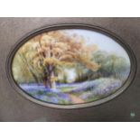 A Royal Worcester Plaque having blue bells in a woodland scene, signed Rushton, framed with oval