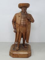 A Treen Tobacco Jar in the form of a Gentleman smoking a Pipe, with Walking Stick, wearing Tricorn