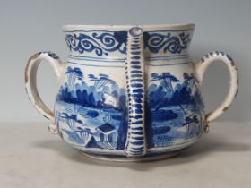 A Delft blue and white two handled Posset Pot with scrolled frieze with Chinese Chinoiseries