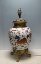 A Chinese porcelain and gilt metal Table Lamp with design of dragons and flowers and raised on