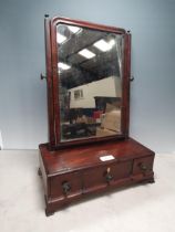 A Georgian mahogany Dressing Mirror with shaped rectangular plate on platform base fitted three