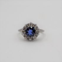 A Sapphire and Diamond Cluster Ring claw-set round sapphire within a frame of ten old-cut