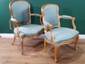 A pair of 19th Century French giltwood Armchairs with shaped backs and seats and raised on