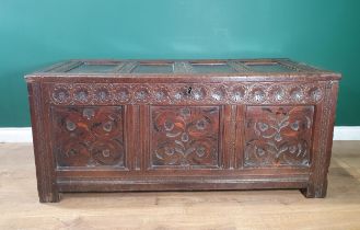 An 18th Century oak Coffer with panelled hinged top, flower head carved frieze above inlaid