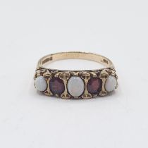 An Opal and Garnet five stone Ring set three graduated oval opal cabochons interspersed with two