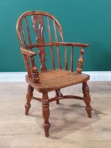 An ash and yew child's Windsor Armchair with pierced splat back raised on turned supports united