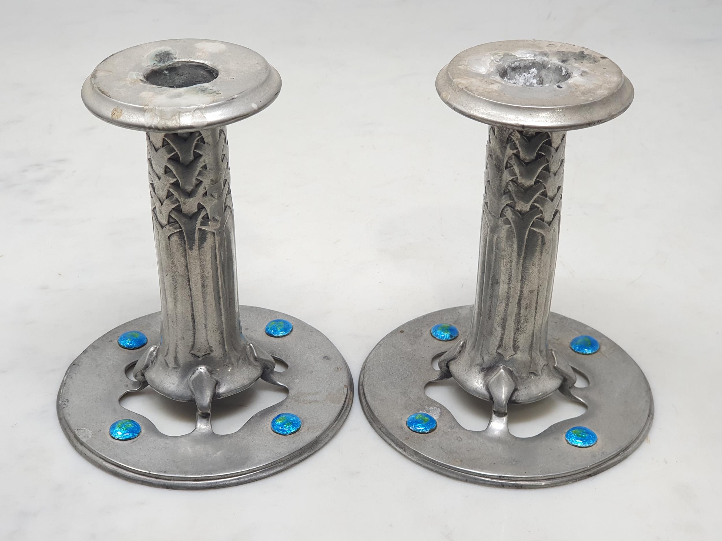 A pair of Arts and Crafts "Liberty and Co - Tudric Pewter" Squat Candlesticks with stylised