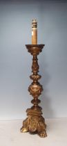 An 18th Century giltwood Candlestick with cherub mask and leafage and scrolled designs, raised on