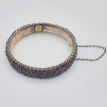 A Garnet set hinged Bangle peg-set numerous rose-cut stones