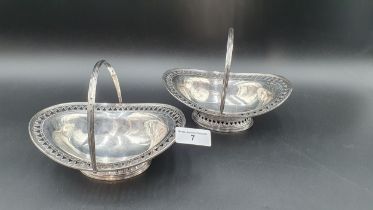 A pair of Victorian silver pierced oval Sweetmeat Baskets with swing handles on pedestal bases,