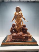 Ian Norbury, a limewood and walnut carved female nude surrounded male figures on a rectangular base,