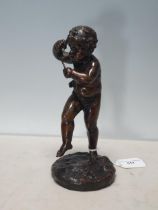 An early 19th Century bronze Cherub playing musical instrument raised on circular base, 9in High (