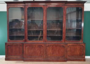 A Regency flame mahogany Breakfront Bookcase, the moulded cornice above four glazed doors