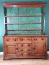 A Georgian oak enclosed Dresser and Rack the base fitted three frieze drawers above pair of