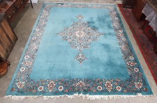 A Chinese blue ground Carpet with central floral medallion and with floral scroll border in camel,