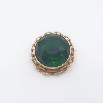 A circular Brooch stamped 9ct set green paste, approx 30mm diameter, approx 17gms