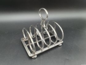 A Victorian silver five bar Toastrack with central handle engraved crest, on bun feet, London