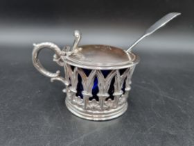 An early Victorian silver Mustard Pot of pierced gothic form, the hinged lid engraved crest, blue