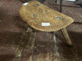 A antique three legged wooden stool.
