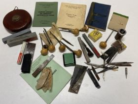 A selection of vintage tools including a tape measure and EC Lyons engravers