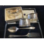 Three hallmarked silver napkin rings and a hallmarked silver spoon and fork set gross weight 67g