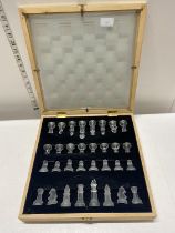 A glass chess set in wooden case with a glass panel chess board. complete