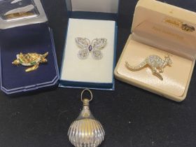 Three boxed brooches/pin and a white metal scent bottle