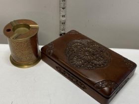 A hand carved smokers box and a metal revolving cigarette holder inlaid with bronze