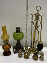 A vintage brass fireside companion set and two coloured glass oil lamps, shipping unavailable