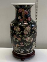 A Chinese ceramic vase with foliage decoration on wooden stand (hole to base) h40cm