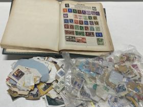 A vintage stamp album and quantity of loose stamps