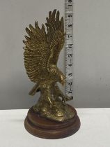 A heavy brass eagle figure on a wooden base