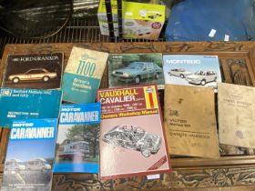 A box full of assorted vintage car manuals