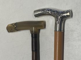 Two vintage walking canes one with horn and gilt metal handle and the other with a hallmarked silver