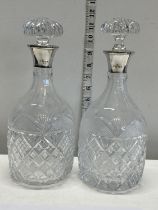 A near pair of quality cut glass decanters with hallmarked silver collars