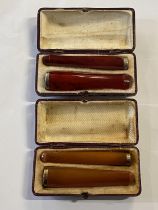 A pair of cased cigarette and cheroot holders (one in Cherry Amber one in Butterscotch Amber)