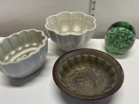 A selection of Victorian ceramic jelly moulds and a Victorian glass dump paperweight