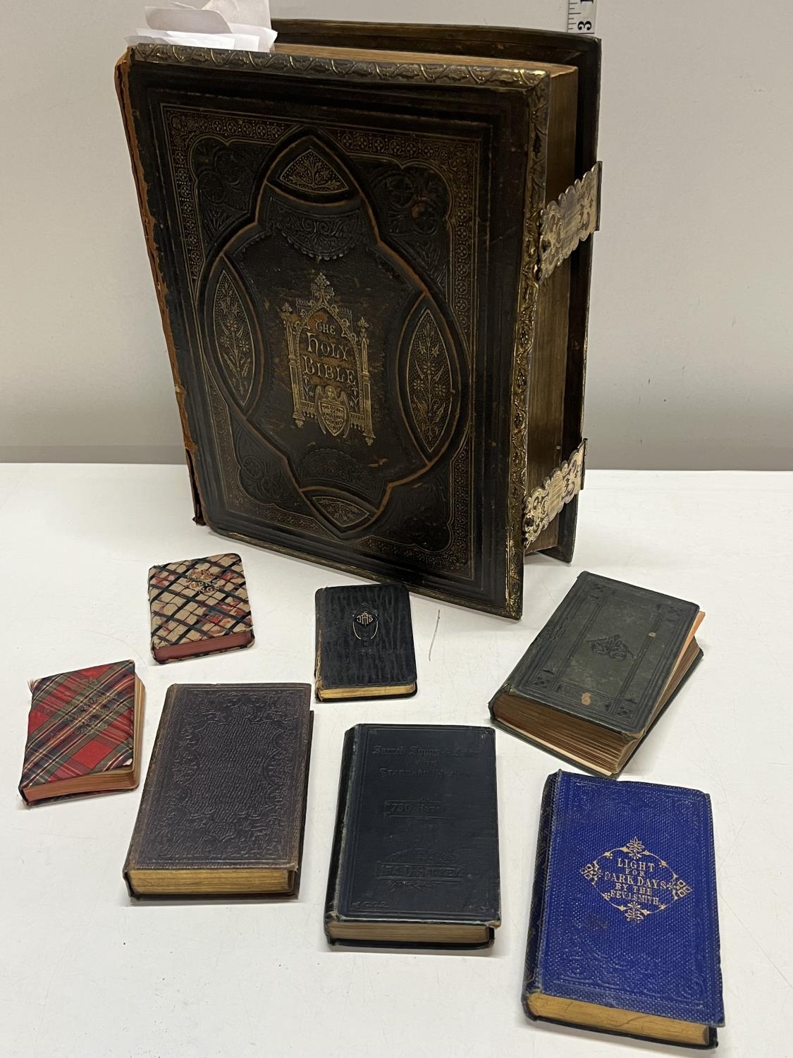 A antique Victoiran family bible with brass clasps a/f and other religious themed books