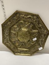 A large hexagonal form brass plaque with dragon form decoration d43cm