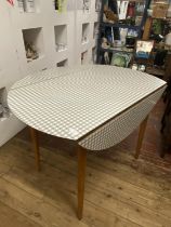 A mid-century Kandja dining table with two drop leaves and checkered formica top, shipping
