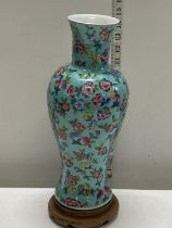 A early Chinese Republic blue glazed vase with flower and fruit decoration on a hardwood stand,