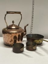 A vintage copper kettle and copper pans