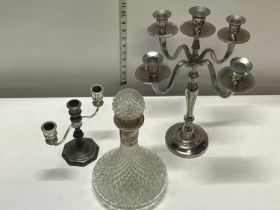 Two silver plated candlesticks and a glass decanter