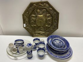 A large brass charger with dragon detailing and a selection of vintage and antique blue and white